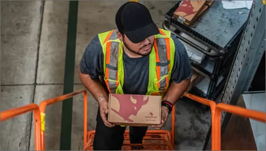 Colaborador subiendo caja de refacciones meritor