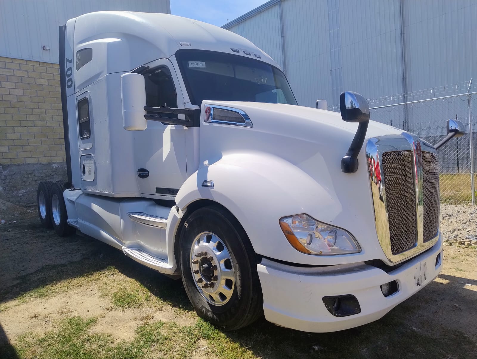 Perfil completo de Kenworth T680 blanco, resaltando rines de aluminio y tanque de combustible.